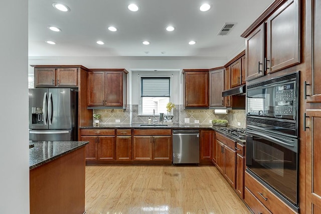 7405 Brookstone Way, Flowery Branch, GA 30542 - kitchen with black appliances, light wood-style floors, dark stone counters, recessed lighting, and tasteful backsplash