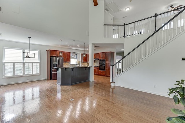 7405 Brookstone Way, Flowery Branch, GA 30542 - unfurnished living room featuring light wood-type flooring, stairway, and plenty of natural light
