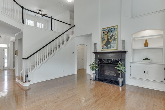 7405 Brookstone Way, Flowery Branch, GA 30542 - living area featuring a high ceiling, stairway, wood finished floors, a ceiling fan, and built in features