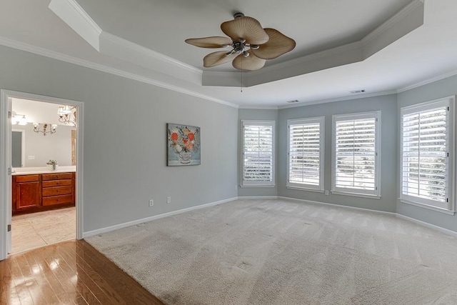 7405 Brookstone Way, Flowery Branch, GA 30542 - empty room featuring a tray ceiling, crown molding, ceiling fan, a chandelier, and light wood-style flooring