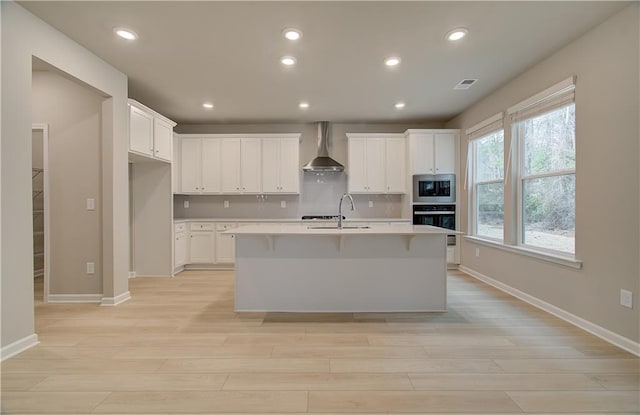 251 Arnewood Cir, Mcdonough, GA 30253 - kitchen with stainless steel microwave, wall chimney exhaust hood, light wood finished floors, black oven, and recessed lighting