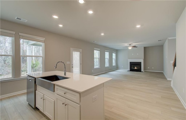 251 Arnewood Cir, Mcdonough, GA 30253 - kitchen featuring stainless steel dishwasher, a ceiling fan, light wood-style floors, recessed lighting, and a glass covered fireplace