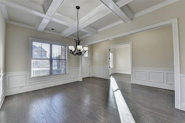 unfurnished dining area featuring beamed ceiling, coffered ceiling, dark hardwood / wood-style floors, and a chandelier