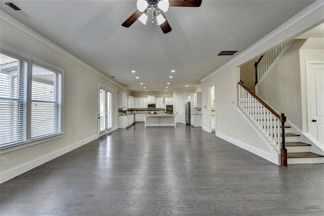 unfurnished living room with ornamental molding, dark wood-type flooring, and ceiling fan