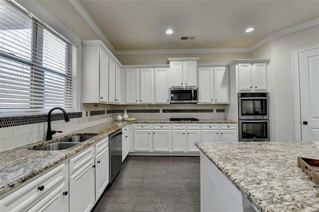 kitchen featuring white cabinetry, sink, decorative backsplash, stainless steel appliances, and crown molding