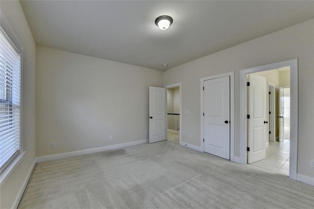 unfurnished bedroom featuring multiple windows and light colored carpet