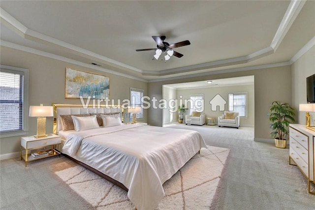 carpeted bedroom with ornamental molding and a raised ceiling