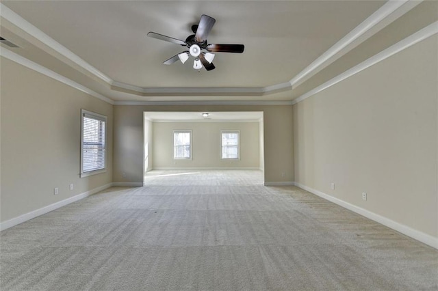 carpeted spare room with crown molding, ceiling fan, and a tray ceiling