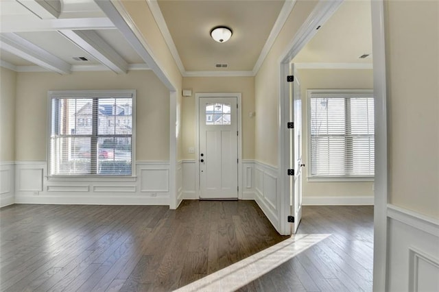 foyer entrance featuring crown molding, dark wood-type flooring, a wealth of natural light, and beam ceiling