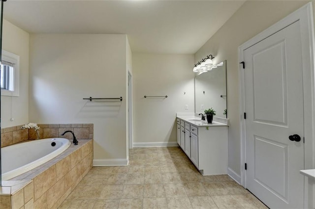 bathroom featuring tile patterned floors, vanity, and tiled tub