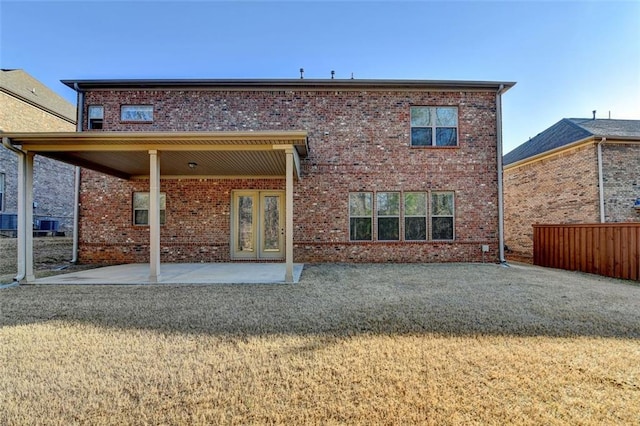 back of house featuring a lawn and a patio