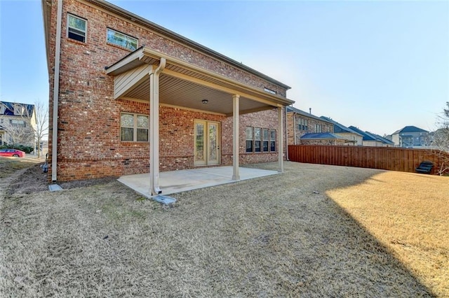 back of property featuring a lawn and a patio