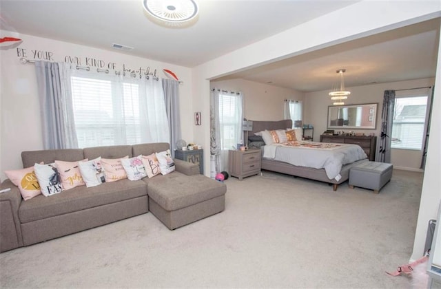 bedroom featuring carpet floors, visible vents, and multiple windows