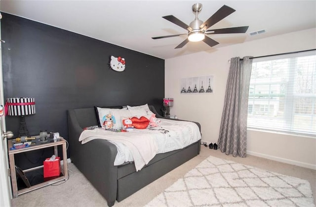 bedroom featuring carpet floors, a ceiling fan, baseboards, and an accent wall