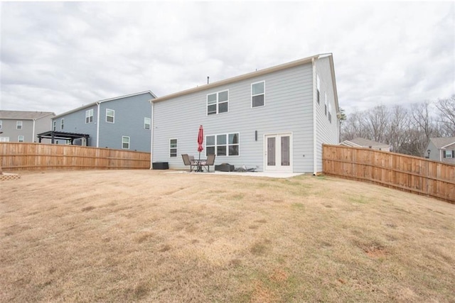 back of house with french doors, a lawn, and fence private yard