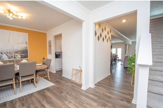 dining room with crown molding, baseboards, stairway, and wood finished floors