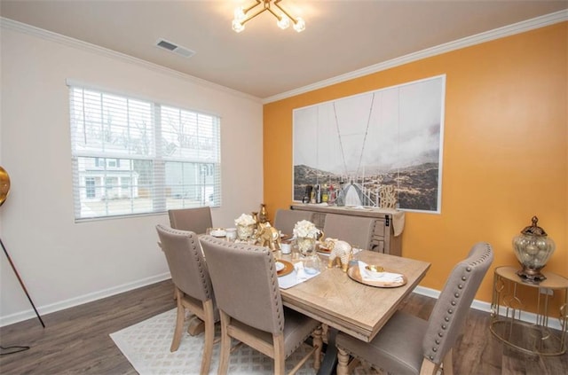 dining room with visible vents, baseboards, crown molding, and wood finished floors