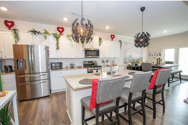 kitchen with an inviting chandelier, a sink, appliances with stainless steel finishes, and visible vents