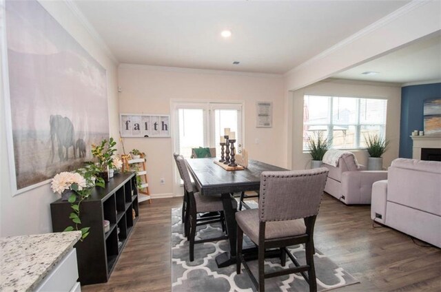 dining room featuring crown molding, dark wood-style flooring, recessed lighting, and a fireplace