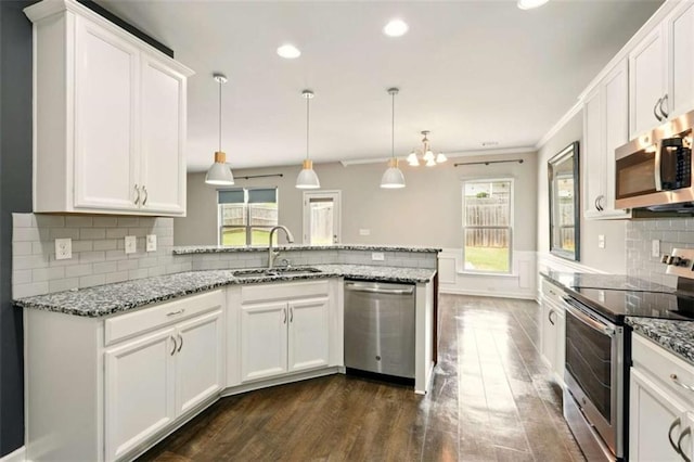 119 Hardy Water Dr, Lawrenceville, GA 30045 - kitchen featuring stainless steel appliances, a sink, dark wood-style flooring, a peninsula, and white cabinetry
