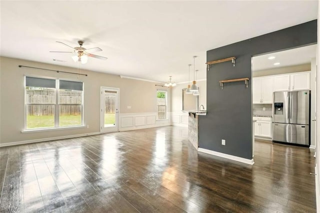 119 Hardy Water Dr, Lawrenceville, GA 30045 - unfurnished living room featuring ceiling fan, dark wood-style floors, a chandelier, and a wainscoted wall