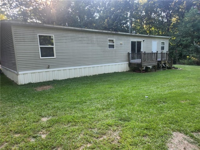 rear view of house with a deck and a lawn