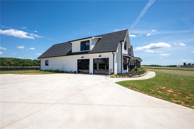 rear view of house featuring a yard and a garage