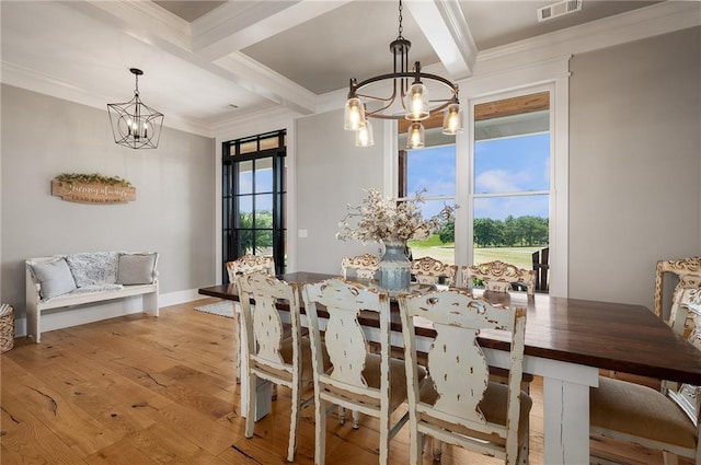 dining room with beamed ceiling, ornamental molding, a chandelier, and light hardwood / wood-style floors