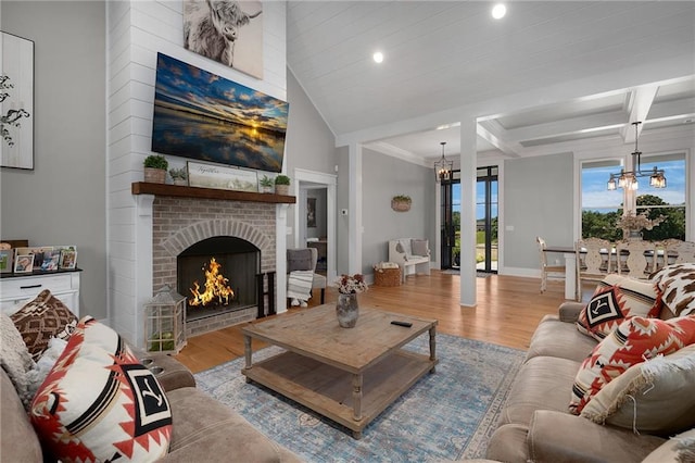 living room with a fireplace, a chandelier, and light hardwood / wood-style floors