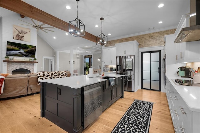 kitchen with a large island, decorative light fixtures, white cabinetry, and wall chimney exhaust hood