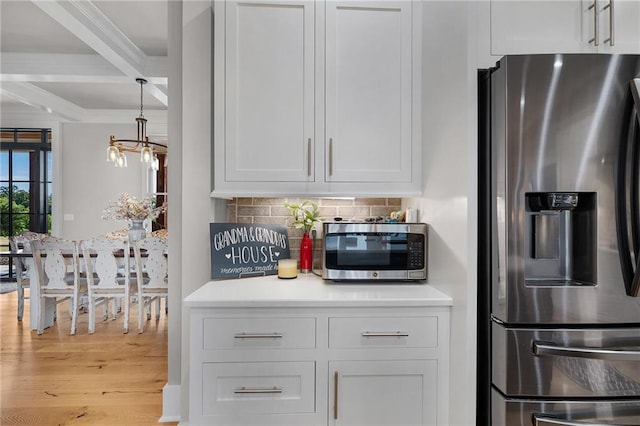 kitchen featuring tasteful backsplash, white cabinetry, coffered ceiling, stainless steel appliances, and beam ceiling