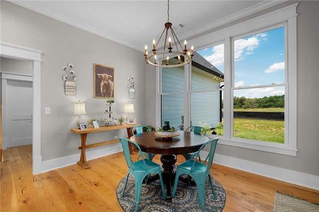 dining room featuring ornamental molding, a chandelier, and light hardwood / wood-style flooring