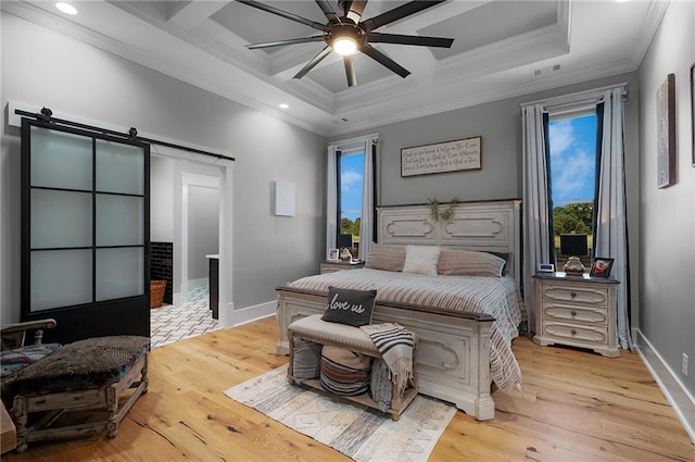 bedroom featuring ornamental molding, a barn door, coffered ceiling, and light hardwood / wood-style floors