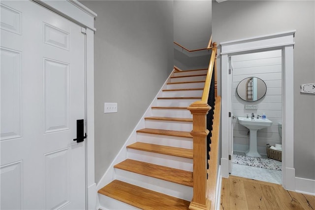 stairway featuring hardwood / wood-style flooring and sink