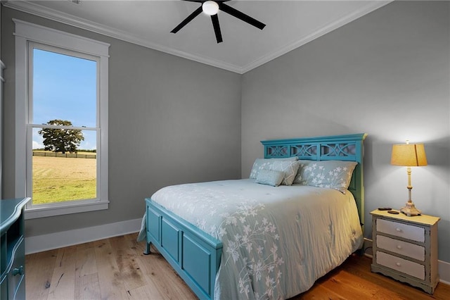 bedroom with crown molding, ceiling fan, and hardwood / wood-style floors