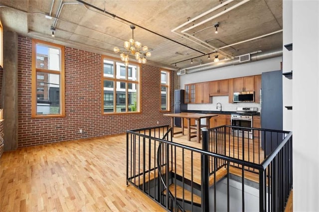 660 Glen Iris Drive # 206 & 109, Atlanta, GA 30308 - kitchen with stainless steel appliances, light wood-type flooring, brick wall, track lighting, and brown cabinets