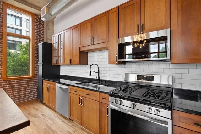 660 Glen Iris Drive # 206 & 109, Atlanta, GA 30308 - kitchen featuring appliances with stainless steel finishes, a sink, light wood-type flooring, backsplash, and brick wall