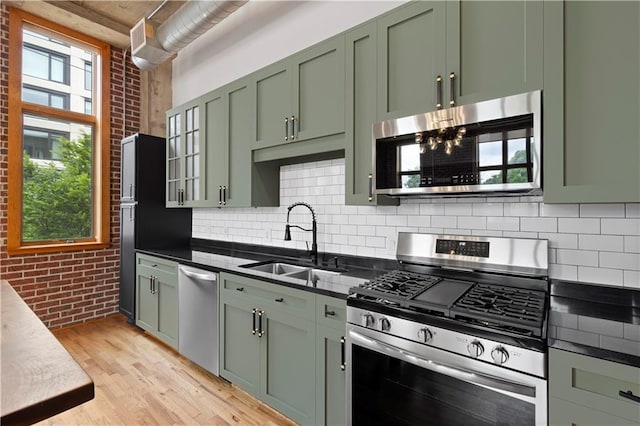660 Glen Iris Drive # 206 & 109, Atlanta, GA 30308 - kitchen featuring stainless steel appliances, light wood-style floors, brick wall, track lighting, and a towering ceiling