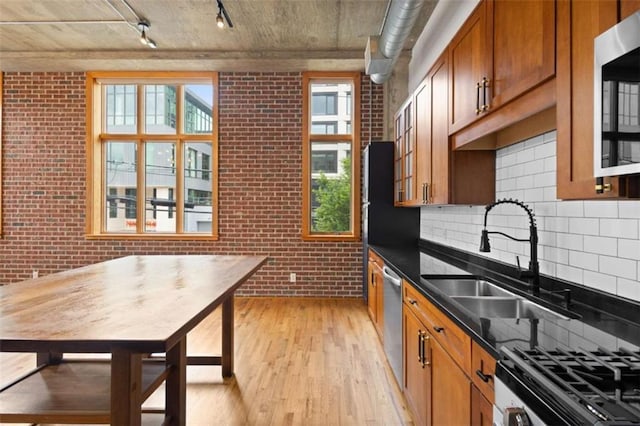 660 Glen Iris Drive # 206 & 109, Atlanta, GA 30308 - kitchen with light wood-type flooring, track lighting, plenty of natural light, stainless steel appliances, and brick wall