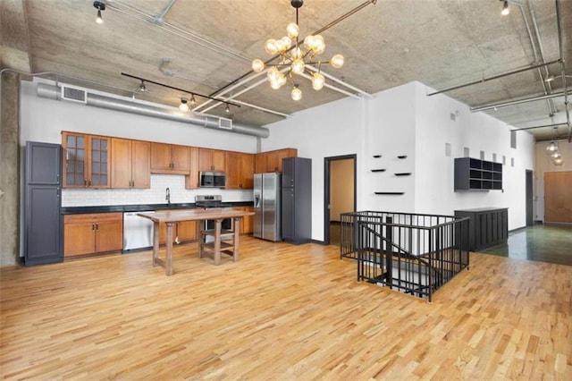 660 Glen Iris Drive # 206 & 109, Atlanta, GA 30308 - kitchen with stainless steel appliances, dark countertops, light wood-type flooring, a high ceiling, and a chandelier