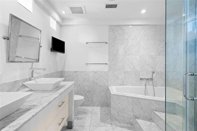 660 Glen Iris Drive # 206 & 109, Atlanta, GA 30308 - bathroom featuring tile walls, double vanity, a garden tub, toilet, and a stall shower