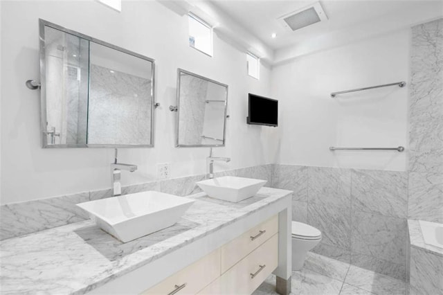 660 Glen Iris Drive # 206 & 109, Atlanta, GA 30308 - full bathroom featuring toilet, double vanity, tile walls, and marble finish floors
