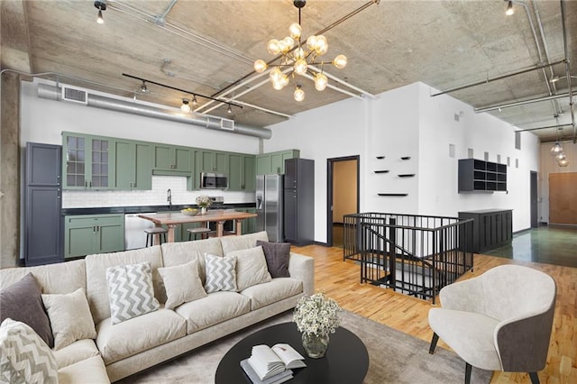 660 Glen Iris Drive # 206 & 109, Atlanta, GA 30308 - living area with a chandelier, light wood finished floors, a towering ceiling, and rail lighting