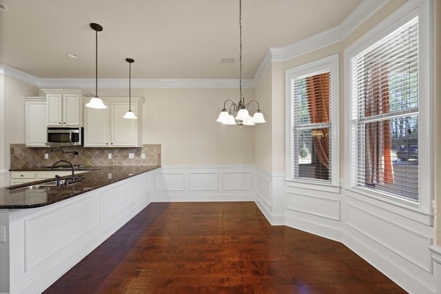 kitchen with dark stone counters, decorative light fixtures, tasteful backsplash, a notable chandelier, and white cabinetry