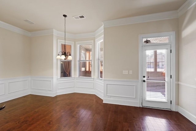 unfurnished dining area with a notable chandelier, crown molding, and dark wood-type flooring