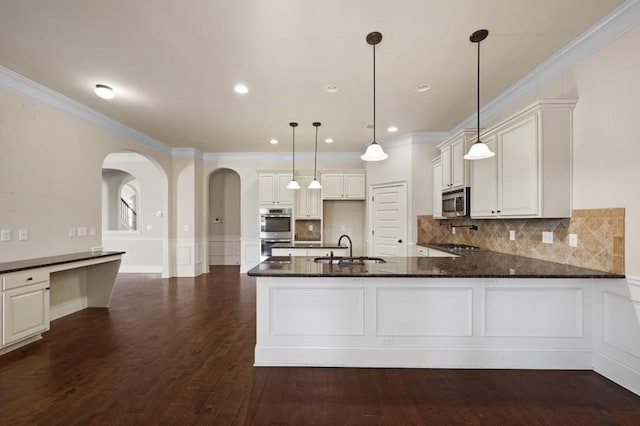 kitchen featuring kitchen peninsula, pendant lighting, decorative backsplash, and sink