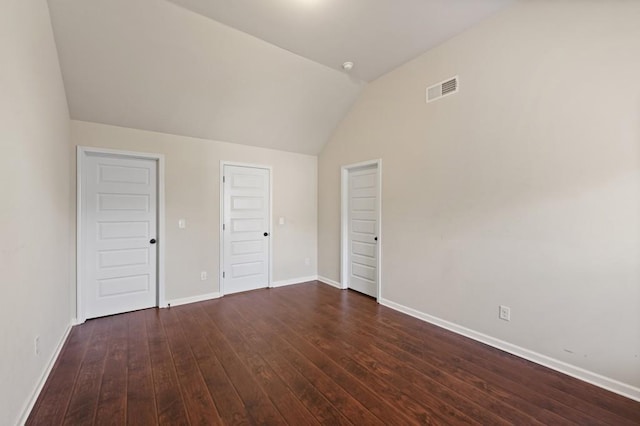 unfurnished bedroom with dark hardwood / wood-style flooring and vaulted ceiling