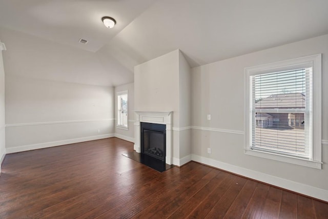 unfurnished living room featuring a healthy amount of sunlight, dark hardwood / wood-style flooring, and vaulted ceiling