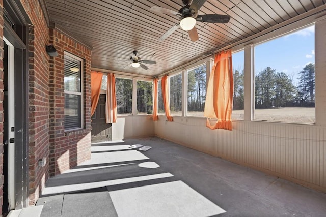 unfurnished sunroom with plenty of natural light, wooden ceiling, and ceiling fan