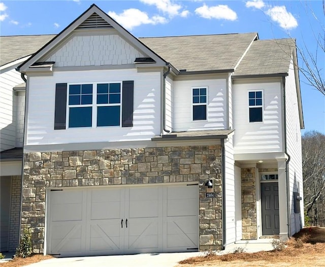 view of front of property featuring a garage and stone siding